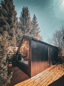 a wooden cabin on a deck in the woods at Moon Resort in Buşteni