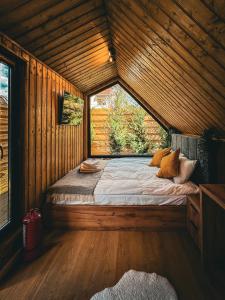 Cama en habitación de madera con ventana en Moon Resort, en Buşteni