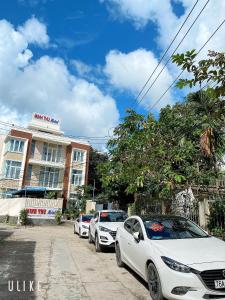 una fila de autos estacionados frente a un edificio en MINH THU MOTEL, en An Bình (1)