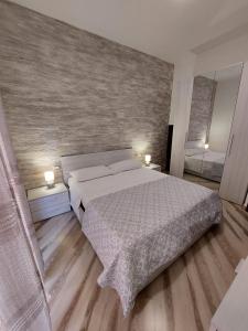 sypialnia z dużym białym łóżkiem z 2 lampami w obiekcie SiricyAus w mieście Ragusa