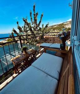 - un balcon avec deux bancs et une table donnant sur l'océan dans l'établissement Apartments Lorena, à Primošten