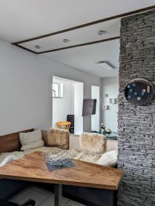 a living room with a couch and a stone wall at Pension Am Waldrand in Mosbach