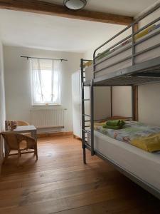een slaapkamer met 2 stapelbedden en een tafel bij Ratstraße im Kyffhäuser - krumm & schief in Bad Frankenhausen