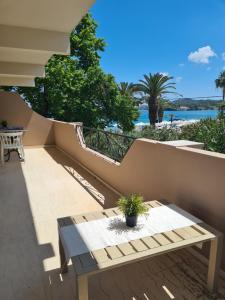 a balcony with a bench and a view of the water at Malibu Summer Studios in Dassia