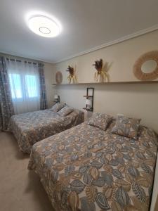 two beds in a hotel room with two beds at Ap-to Frente al Mar VillaRomana in Roquetas de Mar