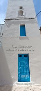 Un edificio bianco con una porta blu sopra di La Dimora di Netta a Carovigno