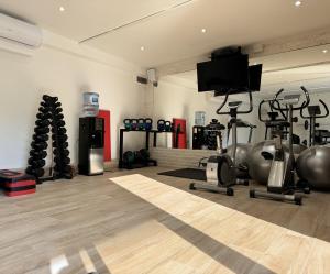 a gym with exercise equipment and a flat screen tv at Villa La Vida in Budva