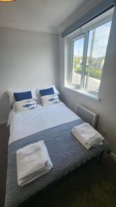 a bedroom with a large bed with towels on it at Top Location Perranporth Apartment in Perranporth