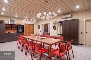 a dining room with a wooden table and red chairs at Dandelion Apartments Lāčplēša in Rīga