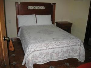 een slaapkamer met een groot bed met een houten hoofdeinde bij Hotel Posada Santa Fe in Ocotlán