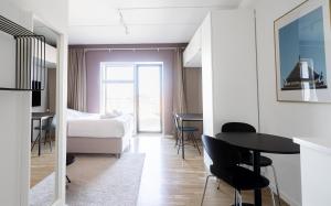a bedroom with a bed and a table and chairs at Cool studio in the South Harbour in Copenhagen
