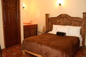 1 dormitorio con 1 cama grande y lavamanos en Hotel Posada Santa Fe, en Ocotlán