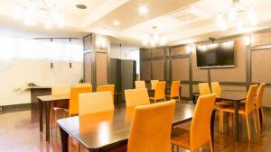 a conference room with a table and yellow chairs at Dogonooyado Iwasaki in Matsuyama