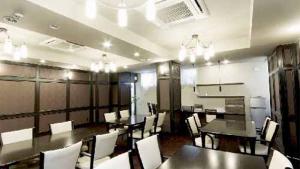 a dining room with tables and chairs in a restaurant at Dogonooyado Iwasaki in Matsuyama