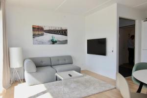 uma sala de estar com um sofá e uma mesa em Cool 1-bed w. private terrace em Odense