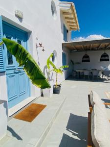 eine Terrasse mit einer blauen Tür und einem Tisch in der Unterkunft Le Blanc in Dassia