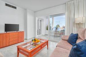 a living room with a couch and a tv at Apartamento Vistamar Marina in Almuñécar