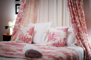 a bed with pink and white sheets and pillows at Les Ecrivains at Domaine Le Touran near Saint Emilion in Pellegrue