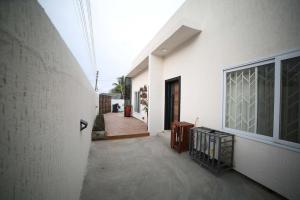 un pasillo de una casa blanca con puerta en The Chelsea TownHouse C en Accra