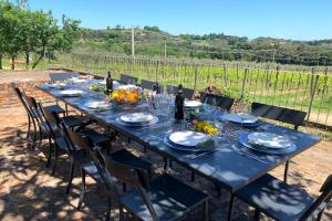 Villa Boschetto by Mmega في مونتيبولسيانو: طاولة زرقاء طويلة مع كراسي وزجاجات نبيذ