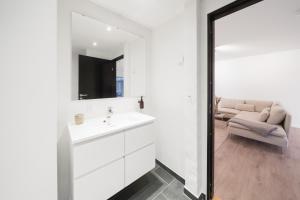 a white bathroom with a sink and a couch at Fantastic apartment wprivate terrace in Aarhus