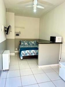 Zimmer mit einem Bett und einem Schreibtisch. in der Unterkunft Casa da Vó Maria! Studio 08 in Goiânia
