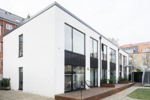 a white building with black windows and a courtyard at Fantastic apartment wprivate terrace in Aarhus