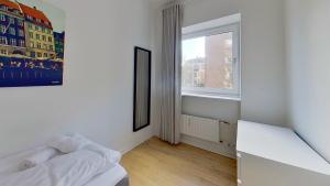 a white room with a bed and a window at Beautiful 2-bed in Frederiksberg C in Copenhagen