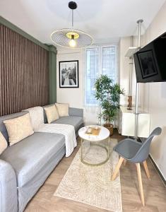 een woonkamer met een bank en een tafel bij 5496 - Studio Montparnasse Olympic Games 2024 in Parijs