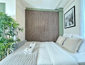 een slaapkamer met een groot wit bed en slippers. bij 5496 - Studio Montparnasse Olympic Games 2024 in Parijs