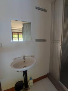 lavabo blanco en el baño con espejo en Thapae waterfall stay, en Ban Tha Phae