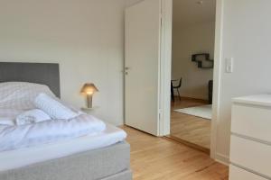 a white bedroom with a bed and a mirror at Fantastic 2-bed in Frederiksberg C in Copenhagen