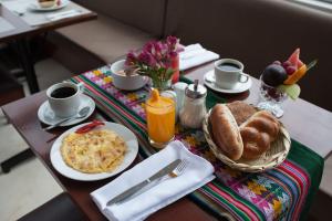 einen Tisch mit einem Frühstück mit Eiern, Brot und Kaffee in der Unterkunft Royal Inn Cusco Hotel in Cusco
