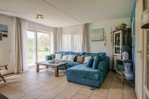 a living room with a blue couch and a table at Appartement Regina - Residence Juliana Julianadorp aan Zee in Julianadorp