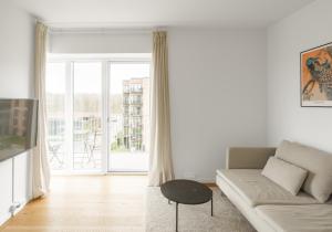Top-class 1-bedroom apartment in Odense في أودنسه: غرفة معيشة مع أريكة ونافذة كبيرة