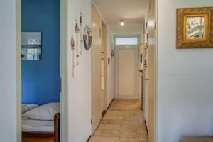 a hallway with blue walls and a room with a bed at Appartement Regina - Residence Juliana Julianadorp aan Zee in Julianadorp