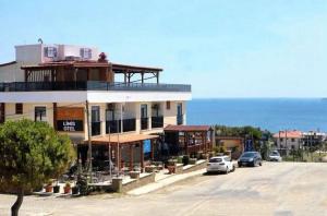 a building with cars parked in front of the ocean at Limis Hotel in Çanakkale
