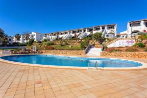 a swimming pool in front of a building at Apartamento Arenal de'n Castell in Arenal d'en Castell