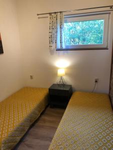 two twin beds in a room with a window at Dom Morski in Lubiatowo