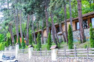 una casa in legno con recinzione e alberi di Haghartsin Hotel and Restaurant a Dilijan