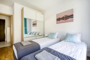 2 Betten in einem Zimmer mit Spiegel in der Unterkunft Labo Apartment Kamionek in Warschau