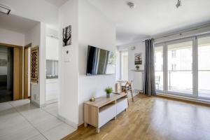 ein Wohnzimmer mit weißen Wänden und einem großen Fenster in der Unterkunft Labo Apartment Kamionek in Warschau