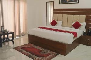 ein Schlafzimmer mit einem großen Bett mit roten Kissen in der Unterkunft Guru Kripa sadan in Vrindāvan