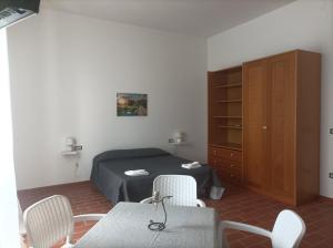 una camera con letto, tavolo e sedie di Dimora Erminia a Polignano a Mare