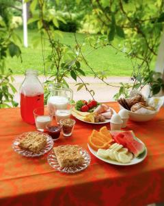 uma mesa vermelha coberta com pratos de alimentos e frutas em Putkisalon Kartano Hellahuoneisto em Rantasalmi