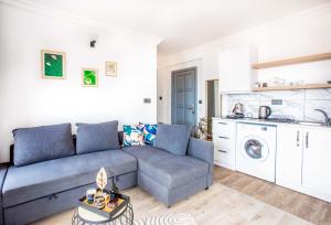 ein Wohnzimmer mit einem Sofa und einer Küche in der Unterkunft Bella Kaş in Kaş