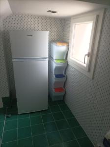 frigorifero bianco in cucina con finestra di Dimora Erminia a Polignano a Mare
