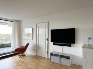 TV a/nebo společenská místnost v ubytování Appartementen met uniek zeezicht