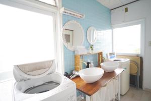 a bathroom with a sink and a washing machine at AKARIYA Home&Hostel in Karatsu