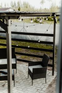 eine Terrasse mit Stühlen und einer Pergola mit Licht in der Unterkunft Atpūtas namiņš pie jūras 'Mierkalni' in Skulte